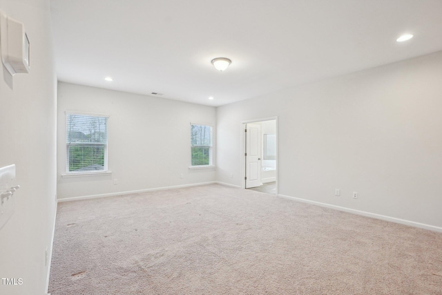 empty room with plenty of natural light, baseboards, and carpet