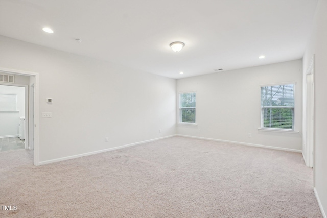 spare room featuring visible vents, light carpet, baseboards, and recessed lighting