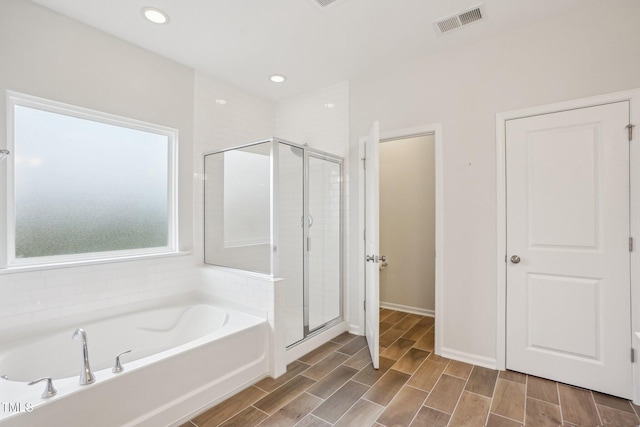 full bathroom with visible vents, a garden tub, a shower stall, and wood finish floors