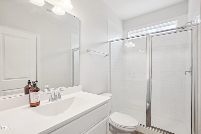 full bath featuring a stall shower, toilet, and vanity