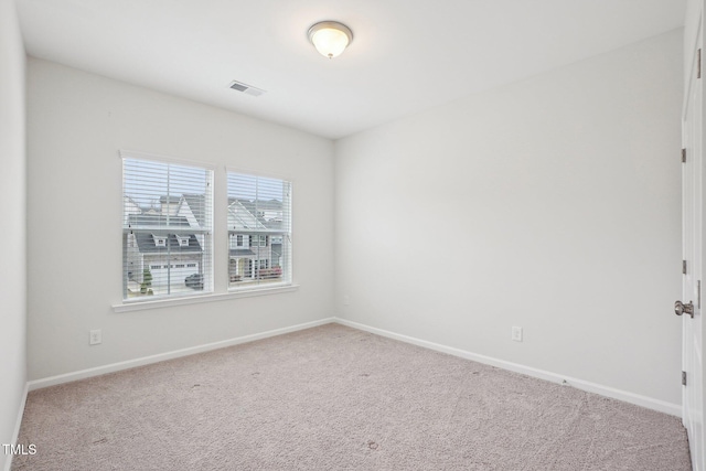 carpeted empty room with baseboards and visible vents
