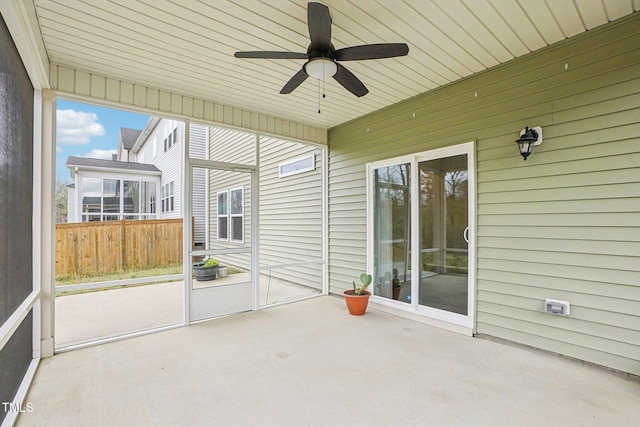 unfurnished sunroom with ceiling fan