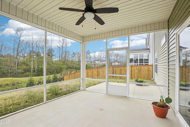 unfurnished sunroom with a ceiling fan