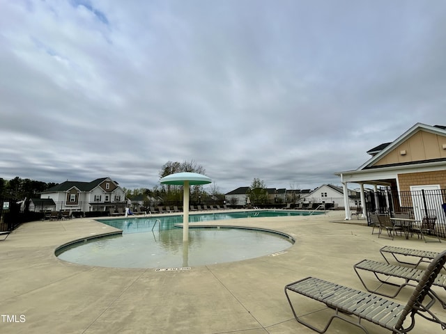 community pool with fence and a patio