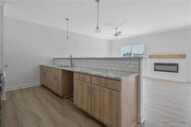 4905 High Branch Ct, Stedman, NC 28391 - kitchen featuring a ceiling fan, a peninsula, light wood-type flooring, light stone counters, and decorative light fixtures