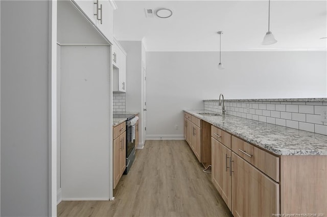 4905 High Branch Ct, Stedman, NC 28391 - kitchen with stainless steel electric range, tasteful backsplash, light wood finished floors, light stone counters, and hanging light fixtures