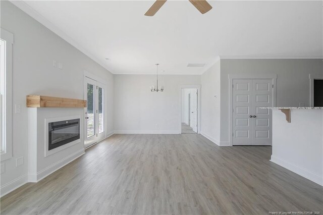 4905 High Branch Ct, Stedman, NC 28391 - unfurnished living room with ceiling fan, a chandelier, ornamental molding, light wood-style floors, and a glass covered fireplace