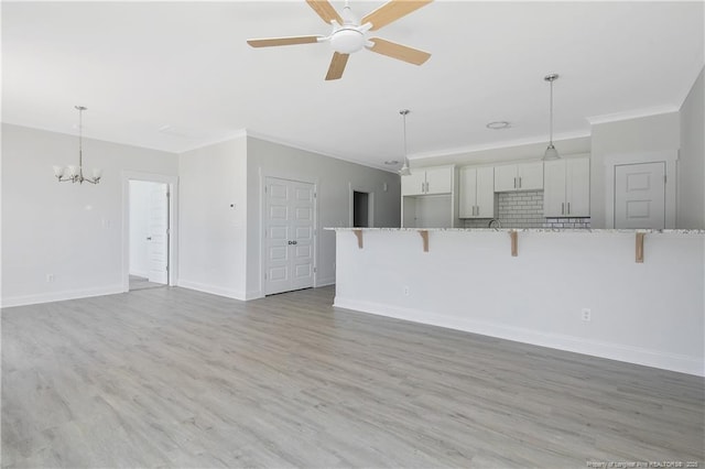 4905 High Branch Ct, Stedman, NC 28391 - unfurnished living room featuring crown molding, a chandelier, light wood-type flooring, and a ceiling fan