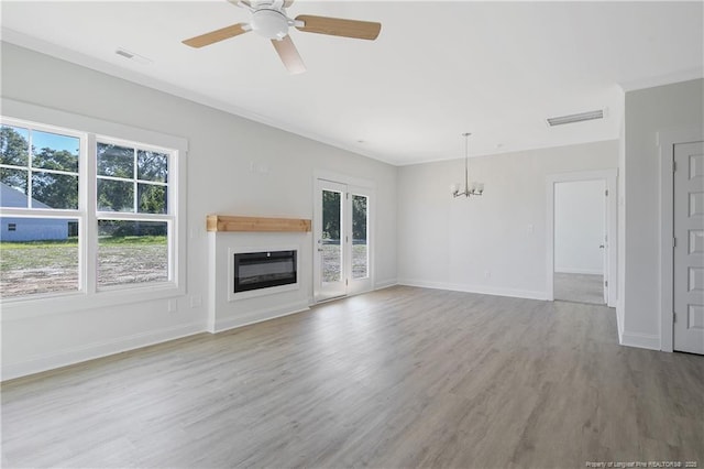 4905 High Branch Ct, Stedman, NC 28391 - unfurnished living room with a chandelier, wood finished floors, a ceiling fan, a glass covered fireplace, and ornamental molding