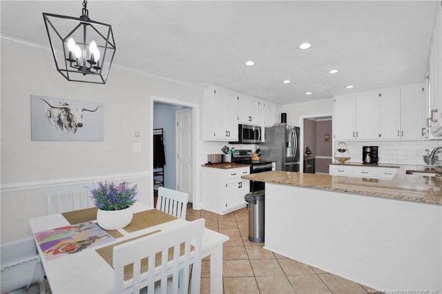 6868 Uppingham Rd, Fayetteville, NC 28306 - kitchen featuring decorative backsplash, light tile patterned flooring, a sink, appliances with stainless steel finishes, and a notable chandelier