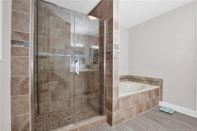 6868 Uppingham Rd, Fayetteville, NC 28306 - full bathroom featuring baseboards, a stall shower, and a garden tub
