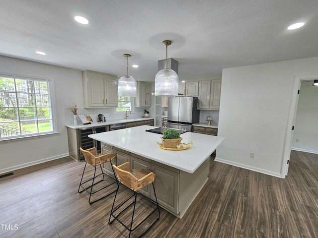 kitchen featuring a sink, beverage cooler, a kitchen bar, and dark wood-style floors
