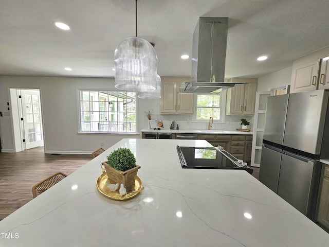 kitchen featuring recessed lighting, freestanding refrigerator, island range hood, a sink, and wood finished floors