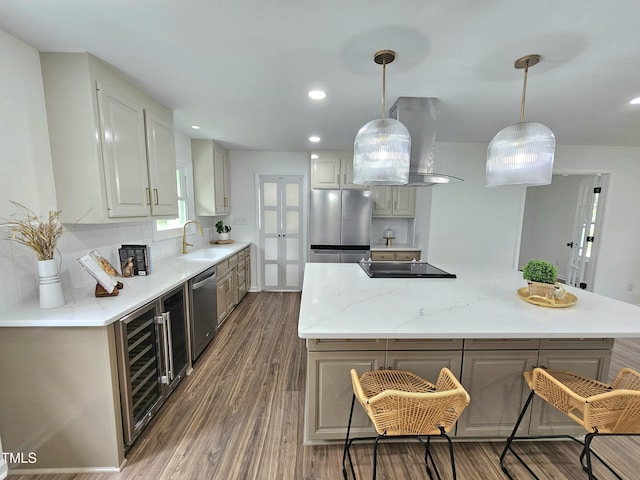 kitchen featuring a center island, wall chimney exhaust hood, wine cooler, appliances with stainless steel finishes, and wood finished floors