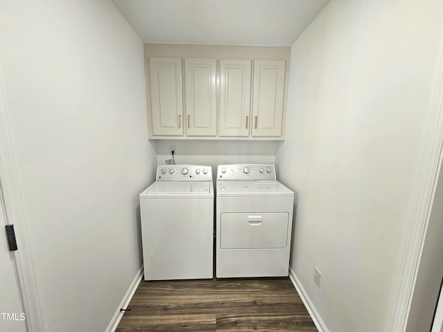 laundry room featuring dark wood-style flooring, washing machine and dryer, baseboards, and cabinet space