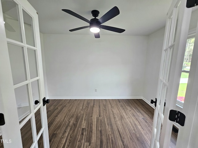 empty room with dark wood-type flooring, french doors, and baseboards