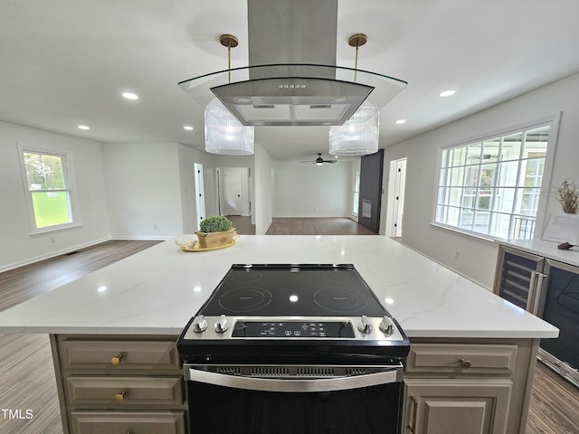 kitchen featuring a ceiling fan, recessed lighting, wood finished floors, electric stove, and open floor plan