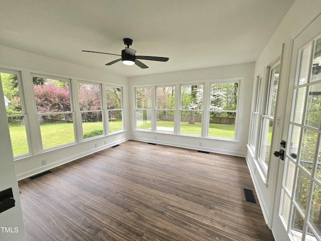 unfurnished sunroom with a wealth of natural light, visible vents, and wood finished floors