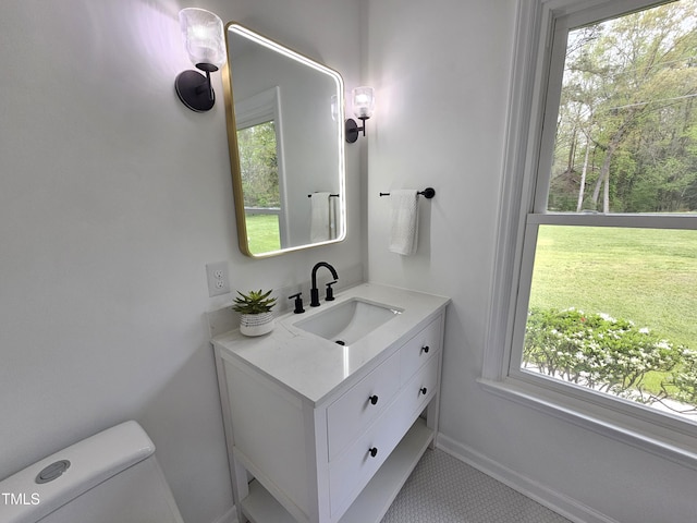 bathroom featuring vanity, baseboards, and toilet
