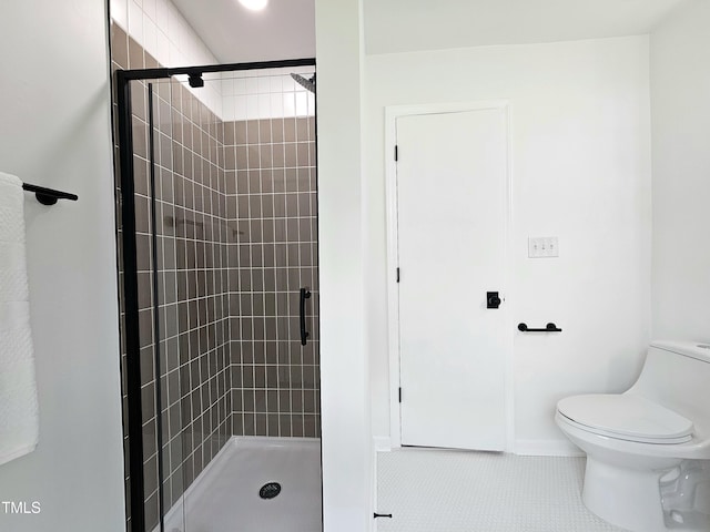 bathroom featuring a shower stall, tile patterned flooring, and toilet