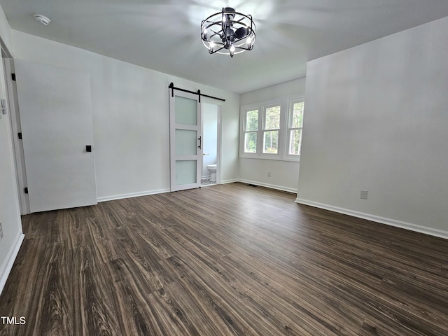 interior space with a barn door, dark wood-style flooring, baseboards, and an inviting chandelier