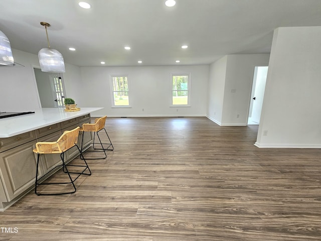 kitchen featuring recessed lighting, wood finished floors, light countertops, open floor plan, and baseboards