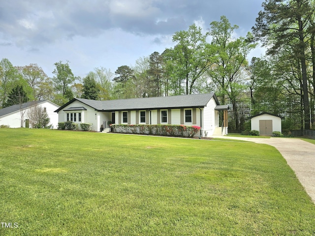 single story home with an outdoor structure, a shed, driveway, and a front lawn