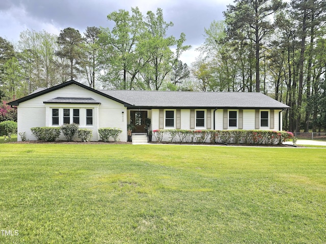 ranch-style house with a shingled roof and a front lawn
