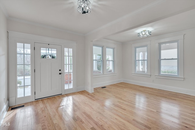 entrance foyer featuring light wood finished floors, baseboards, visible vents, and crown molding