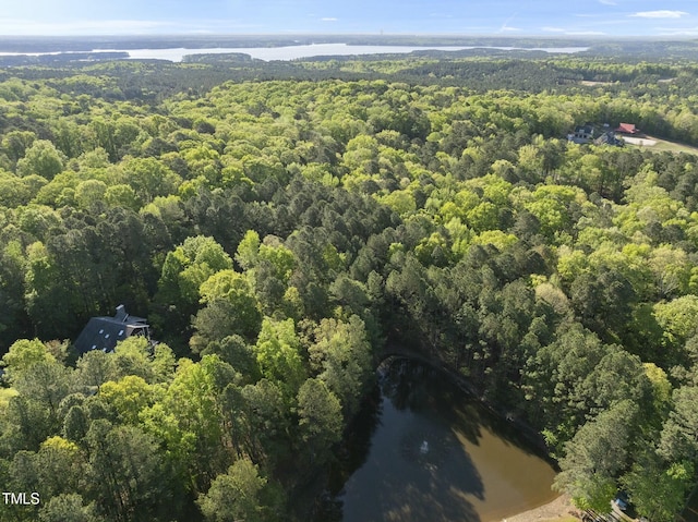 aerial overview of property's location with a heavily wooded area and a nearby body of water