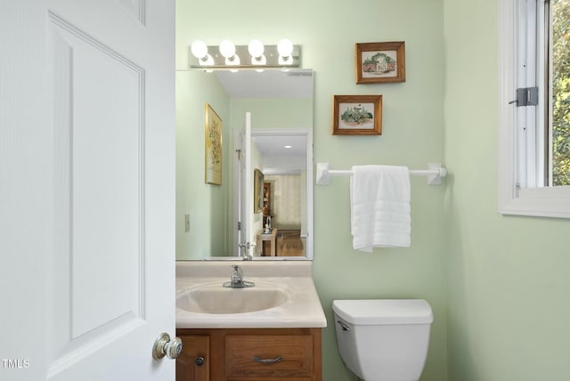 half bathroom with vanity and toilet