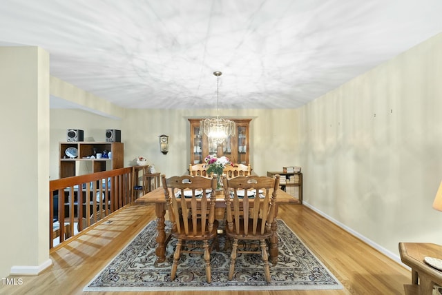 dining area featuring wood finished floors, baseboards, and a chandelier