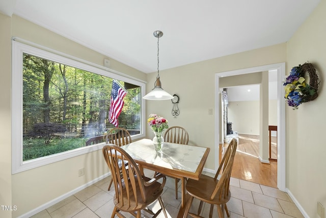 dining space featuring light tile patterned floors and baseboards