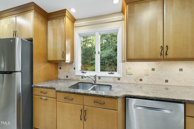 kitchen with stainless steel appliances, a sink, light stone countertops, tasteful backsplash, and recessed lighting