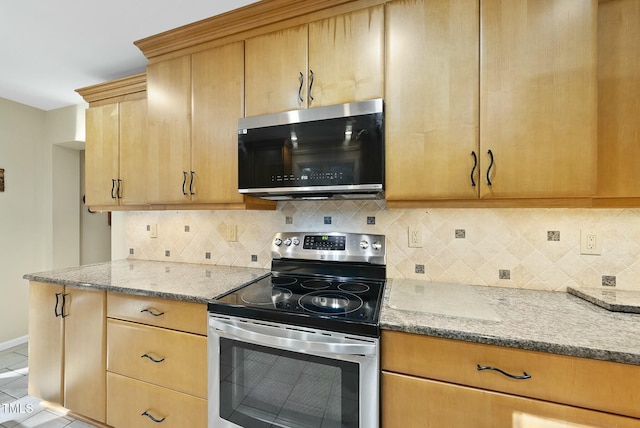 kitchen with stainless steel appliances, light stone countertops, and decorative backsplash