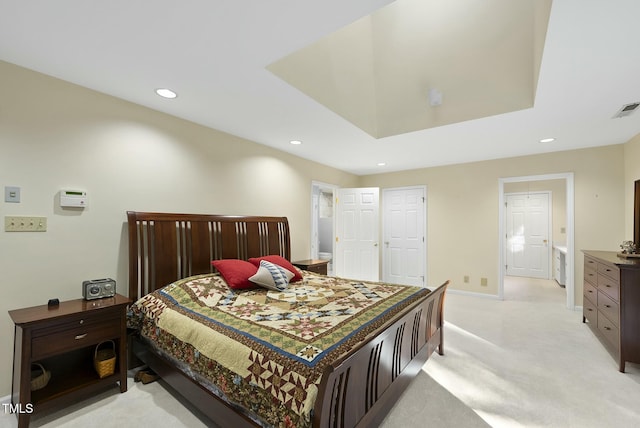 bedroom with recessed lighting, light colored carpet, baseboards, and ensuite bath