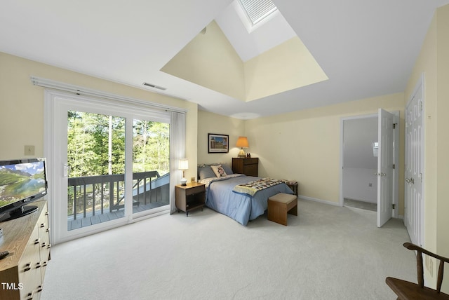 bedroom featuring light carpet, access to exterior, a skylight, and baseboards
