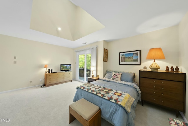 bedroom with access to exterior, carpet floors, a tray ceiling, and baseboards