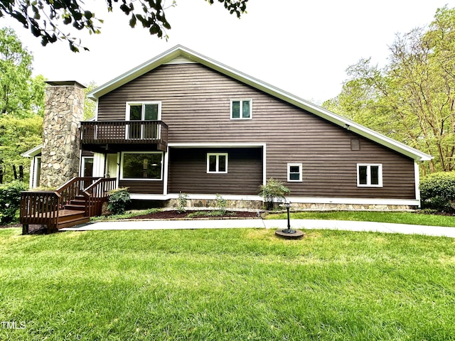 rear view of property with a balcony and a lawn