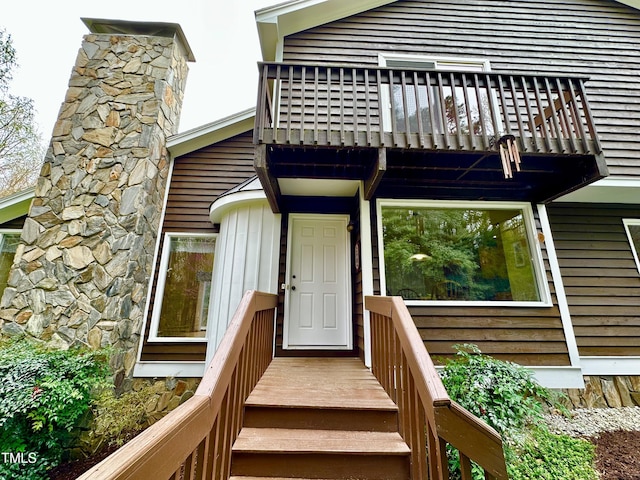 property entrance with a balcony and a chimney