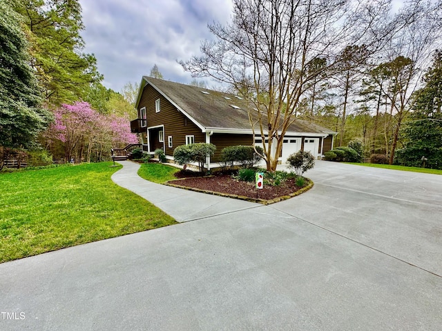 view of side of home featuring concrete driveway, a lawn, and a garage