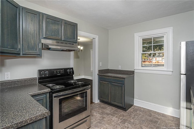kitchen with dark countertops, baseboards, under cabinet range hood, and stainless steel appliances