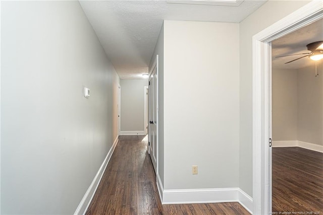 hallway with baseboards and dark wood-style floors