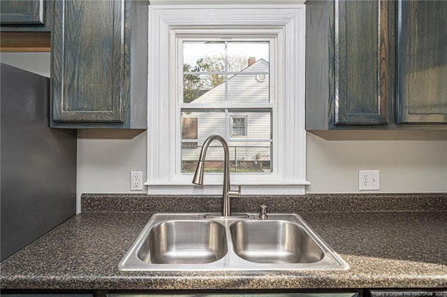 kitchen with dark countertops, dark brown cabinets, and a sink