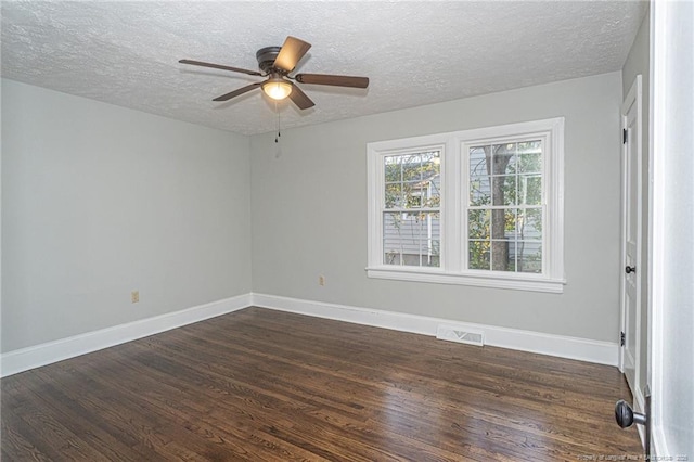 unfurnished room with a textured ceiling, dark wood-style flooring, baseboards, visible vents, and ceiling fan