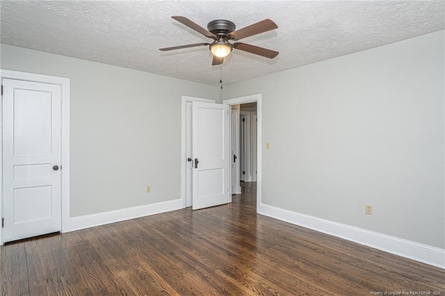 spare room with ceiling fan, baseboards, wood finished floors, and a textured ceiling