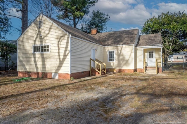 back of property featuring roof with shingles, a chimney, fence, entry steps, and crawl space