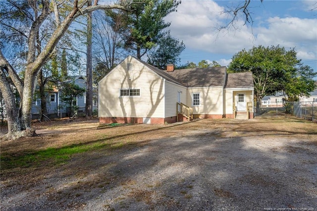 rear view of property featuring entry steps, crawl space, and fence