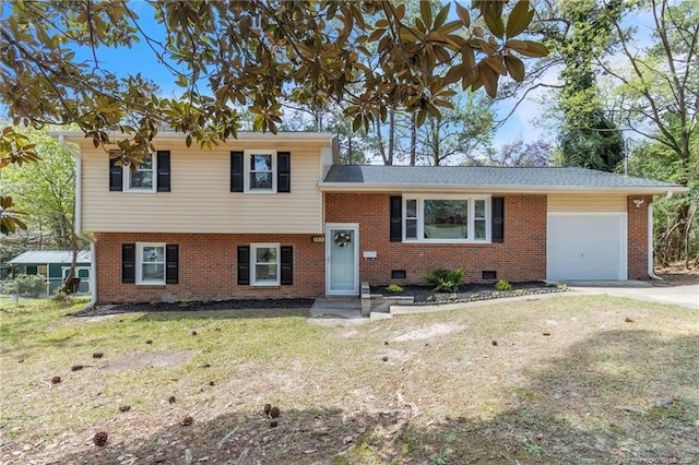 split level home featuring a front yard, a garage, brick siding, and concrete driveway