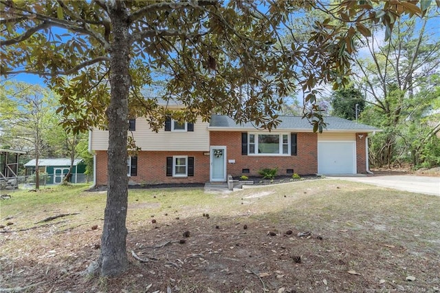 split level home with concrete driveway, fence, an attached garage, a front yard, and brick siding